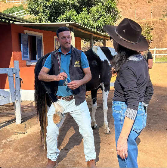 Rafa conversando com cliente e aplicando cuidado atencioso ao cavalo